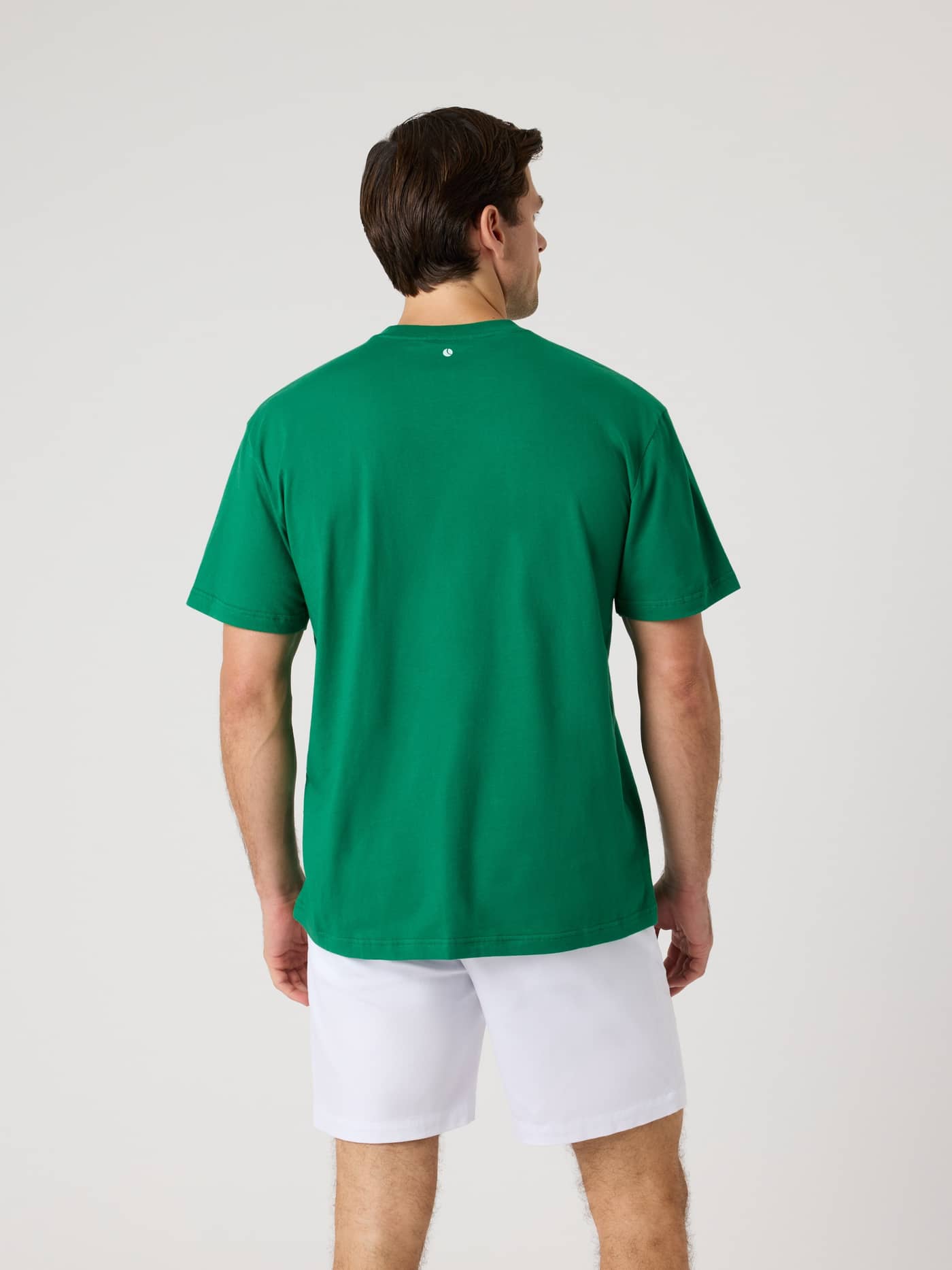 Back view of a man wearing the cotton Borg Classic Print T-Shirt in Verdant Green (Green) with a tennis ball print for golf. - Image 3