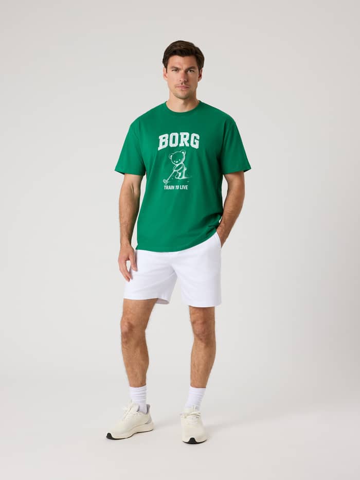 Vorderansicht eines Mannes im Borg Classic Print T-Shirt aus Baumwolle in Verdant Green (Grün) mit weißer Golf-Grafik. - Image 4