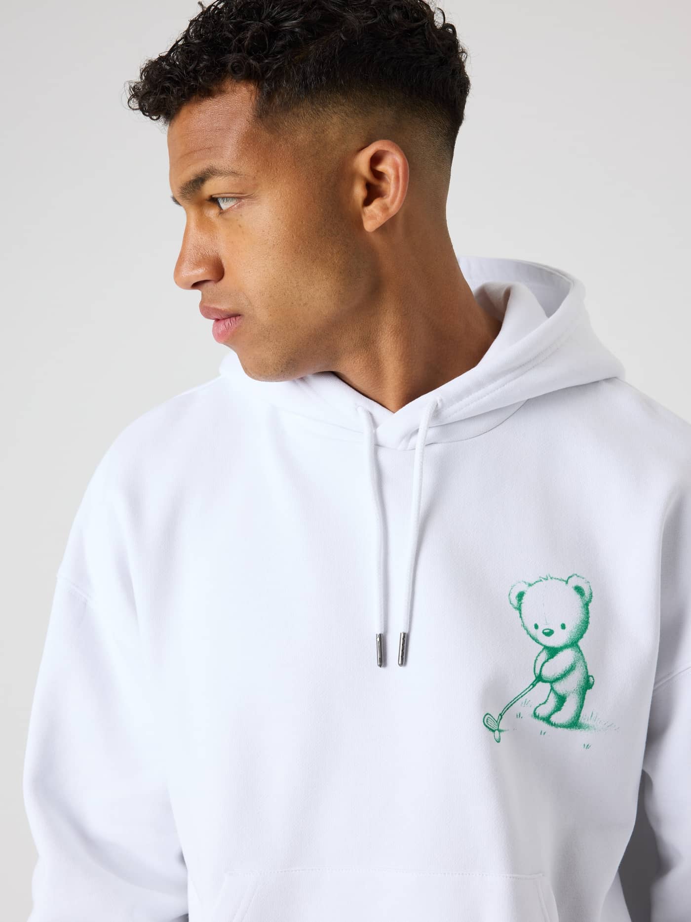 Nahaufnahme des Borg Oversized Hoodie in Brilliant White (Weiß) mit grüner Golf-Grafik für Stil und Funktion beim Golf. - Image 5
