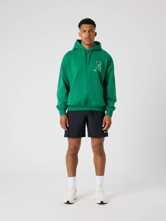 Full-body front view of a man wearing the cotton Borg Oversized Hoodie in Verdant Green (Green) with a white golf graphic. - Image 3
