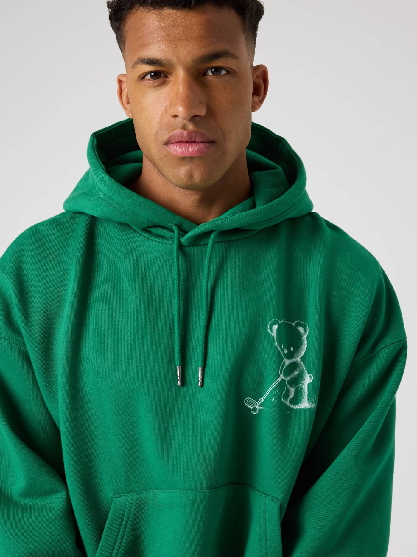 Vista frontal de la Borg Oversized Hoodie en Verdant Green (Verde) para hombre con gráfico de oso de golf en el pecho. - Image 5