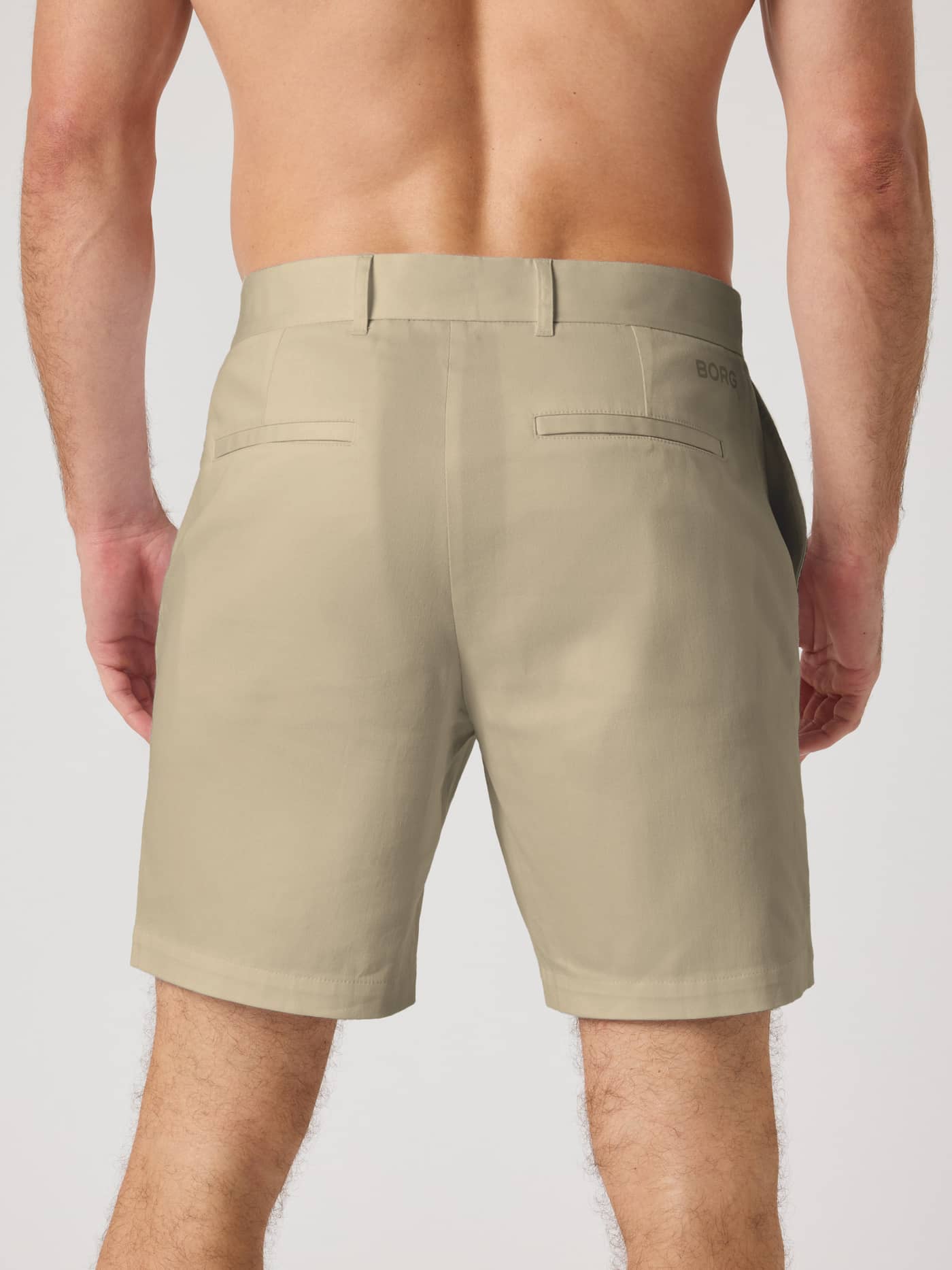Vy bakifrån på Borg Golf Chinos Shorts i Safari (Beige) med en svart logotyp, perfekt för golf. - Image 3