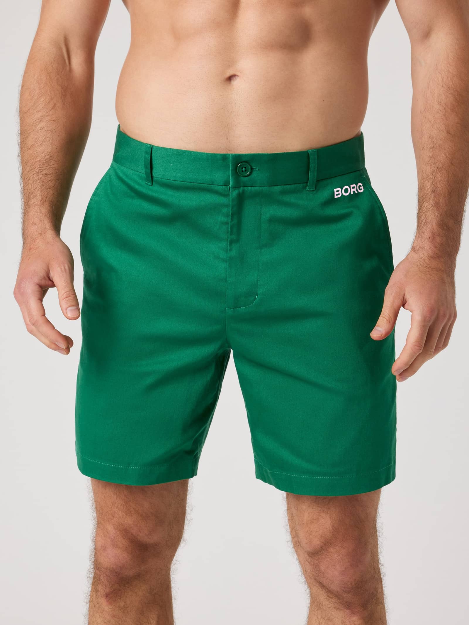 Front view of a man wearing the Borg Golf Chinos Shorts in Verdant Green (Green) with a white BORG logo for golf performance. - Image 1