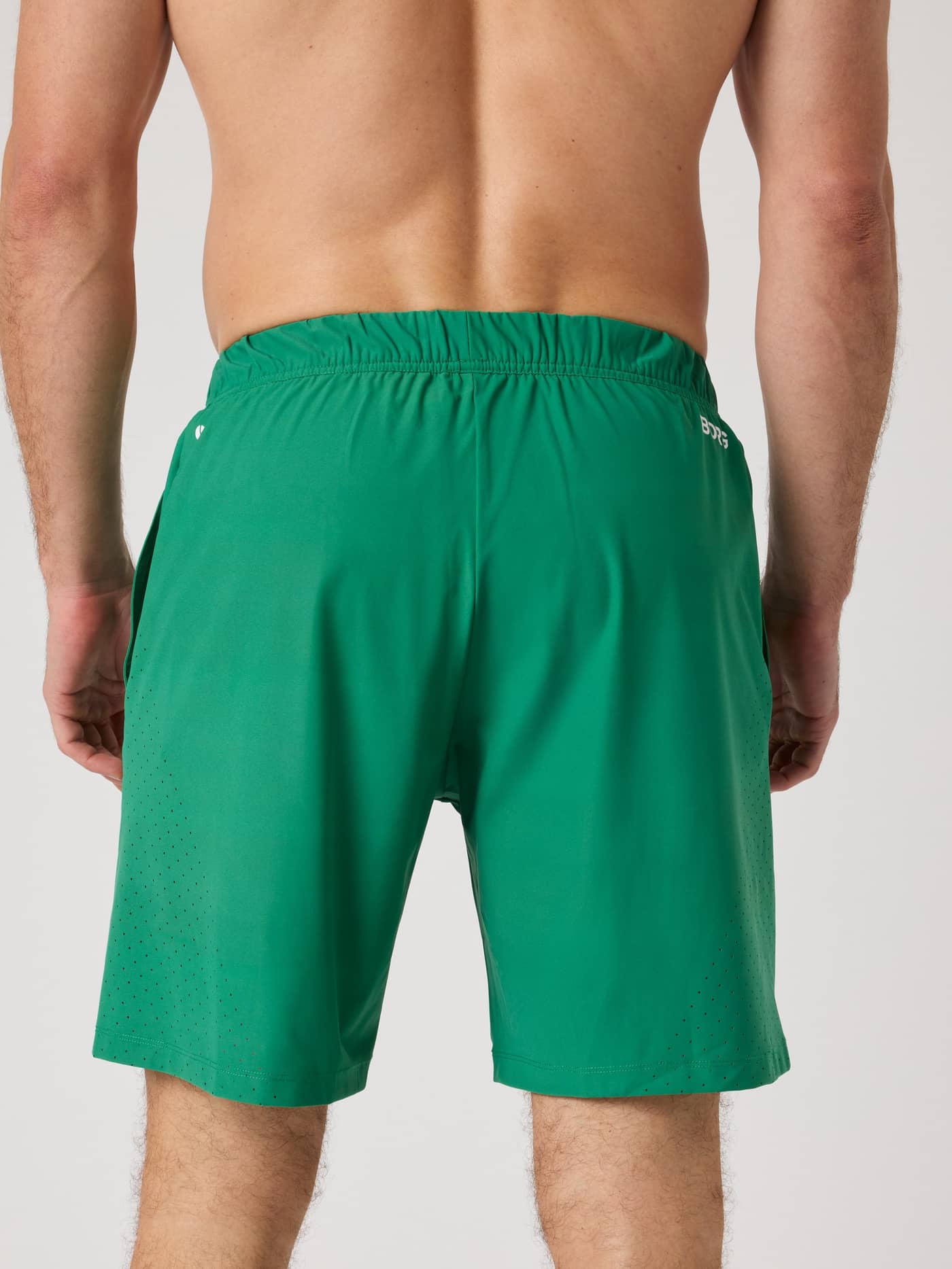 Back view of a man wearing the Borg Golf Sports Shorts 8 Inch in Verdant Green (Green) with perforated leg details. - Image 2