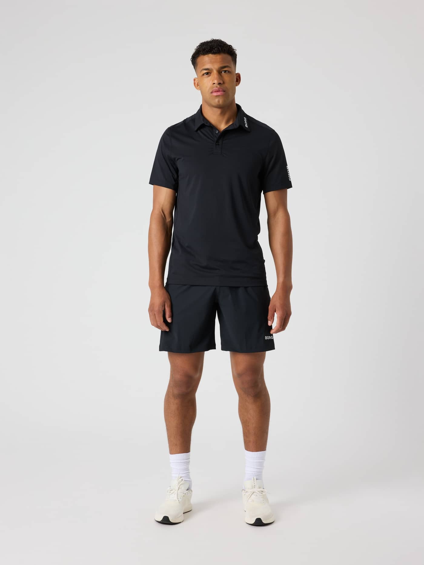 Full-body front view of a man wearing the Borg Golf Sports Shorts 8 Inch in Black Beauty (Black) for golf performance. - Image 3