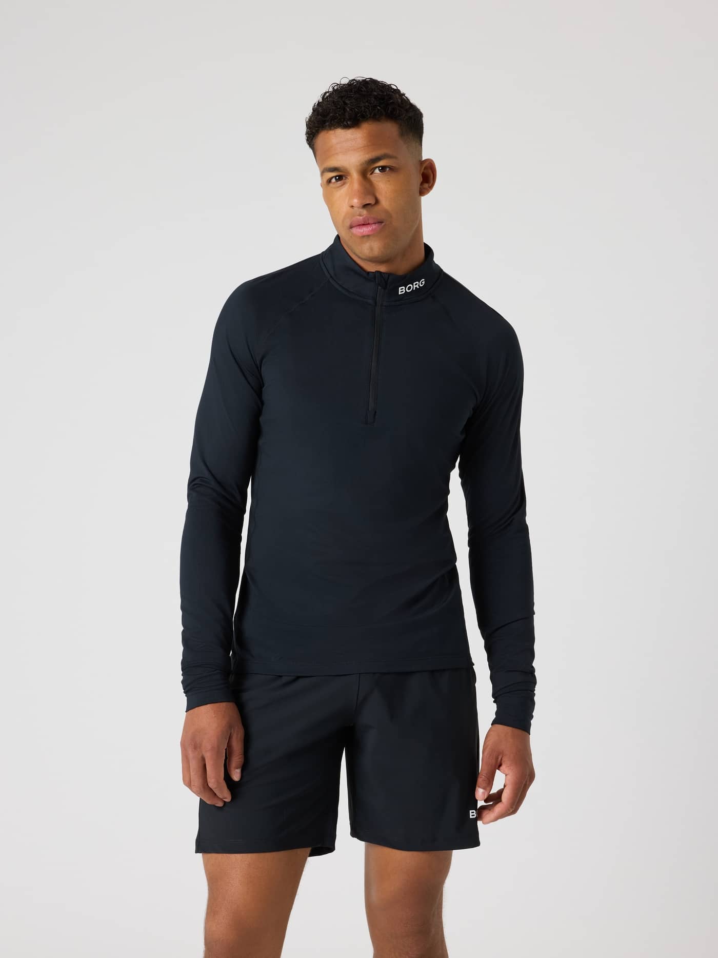 Vorderansicht eines Mannes im Borg Golf Midlayer Half Zip in Black Beauty (Schwarz) für Style und Golf-Funktion. - Image 1