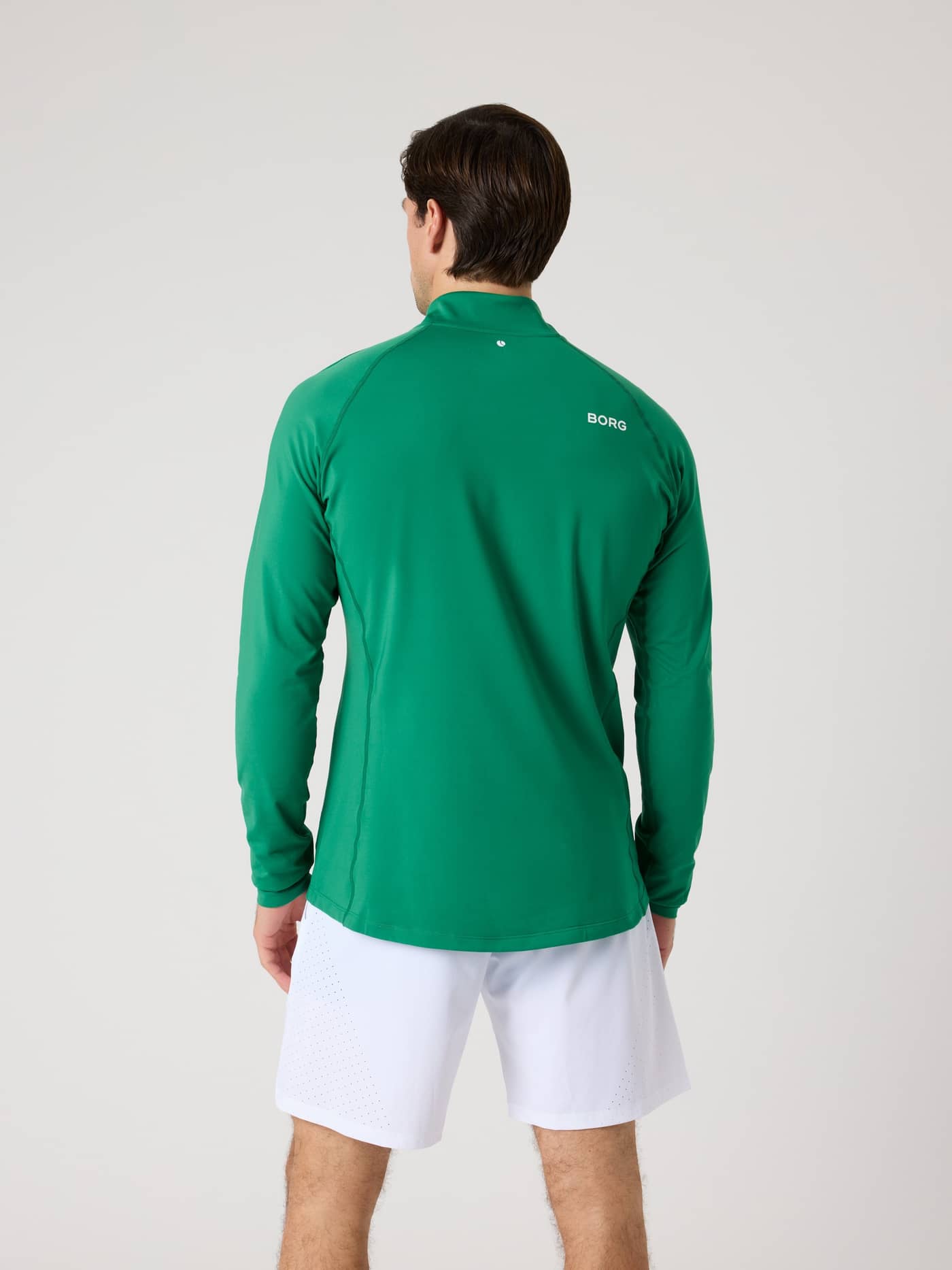 Back view of a man wearing the Borg Golf Midlayer Half Zip in Verdant Green (Green) with a white logo for golf style. - Image 2