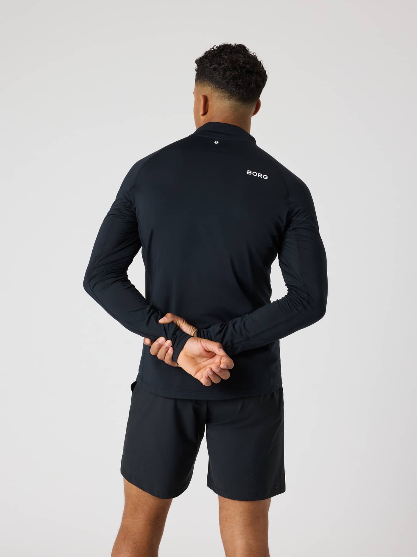 Vue de dos d'un homme en Borg Golf Midlayer Half Zip Black Beauty (Noir) avec logo blanc et détails de golf et tennis. - Image 2