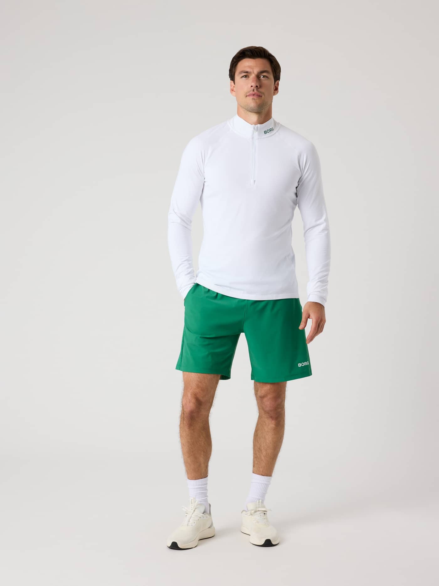 Man in de functionele Borg Golf Midlayer Half Zip in Brilliant White (Wit) met groene details voor stijl en golf. - Image 3