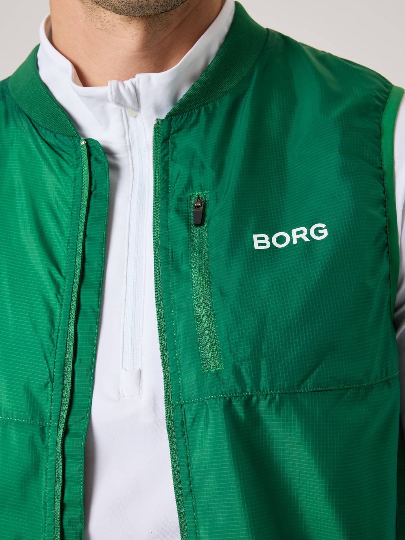 Primer plano frontal del Borg Golf Vest Ripstop en Verdant Green (Verde) con logo blanco y bolsillo en el pecho. - Image 6