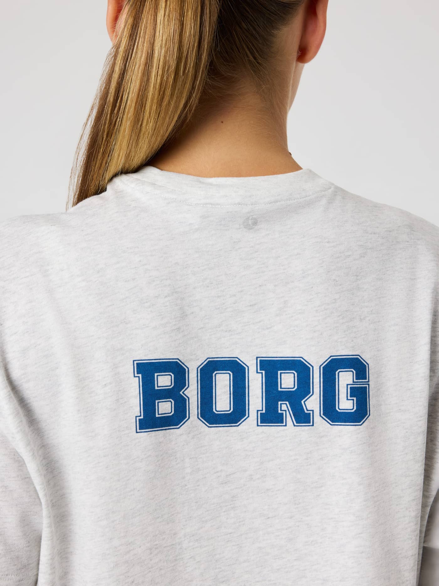 Back view of Studio Oversized Cropped T-Shirt in Ultra Light Grey Melange (Grey) with a blue BORG logo and tennis print. - Image 4