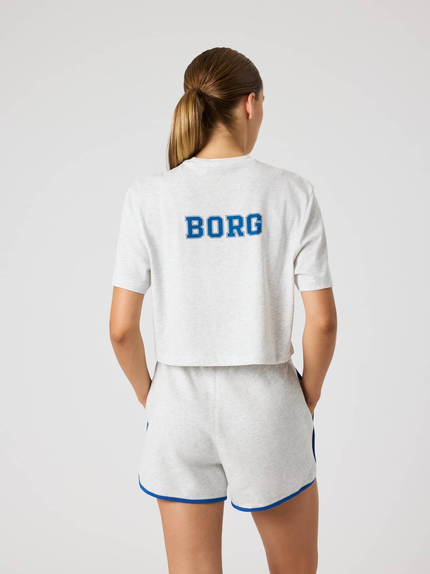 Back view of the Studio Oversized Cropped T-Shirt in Ultra Light Grey Melange (Grey) with a blue BORG logo for tennis. - Image 2