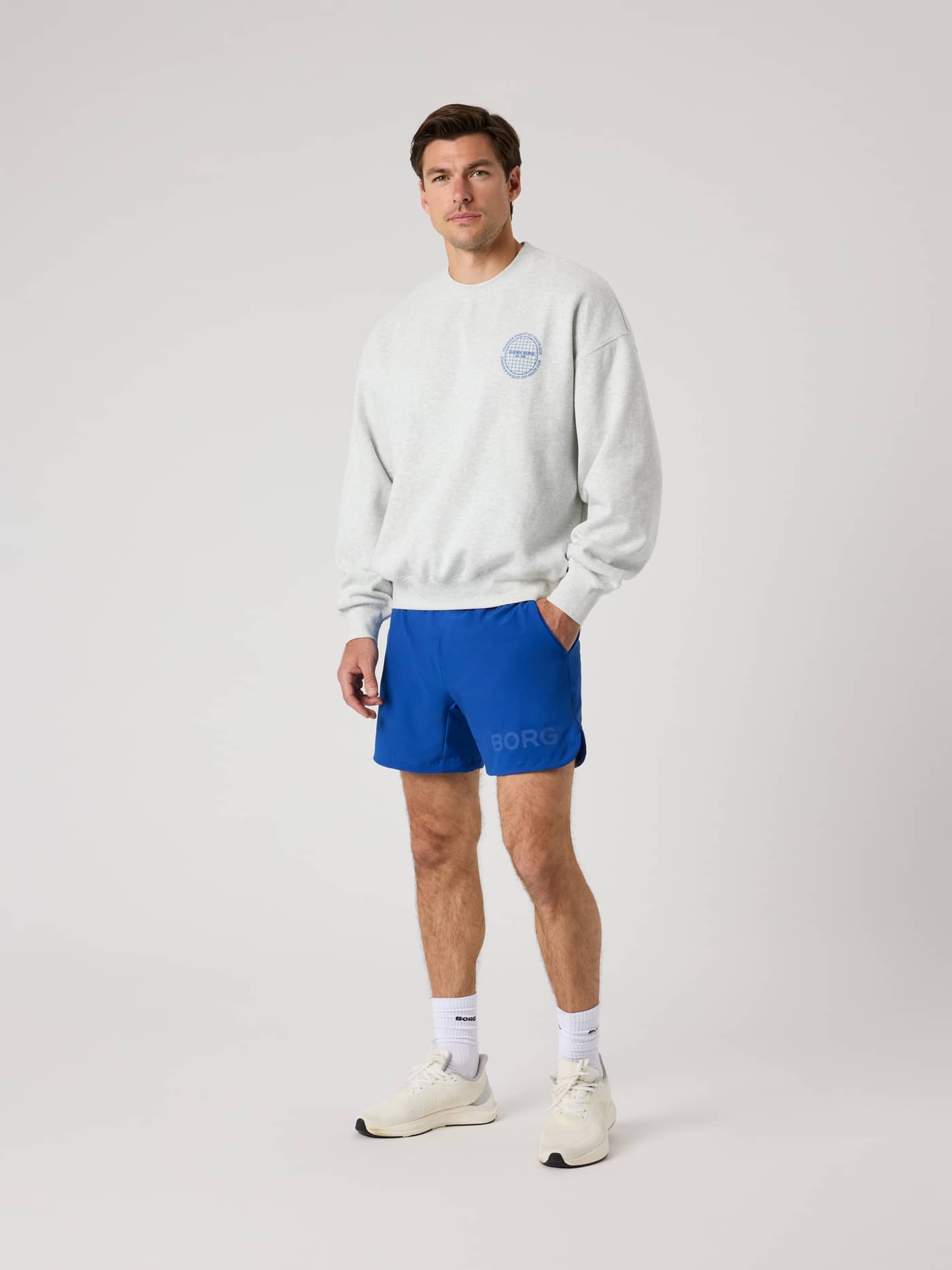 Vista frontal de un hombre con la Ace Oversized Sweatshirt en Ultra Light Grey Melange (Gris) para tenis con logo azul. - Image 3