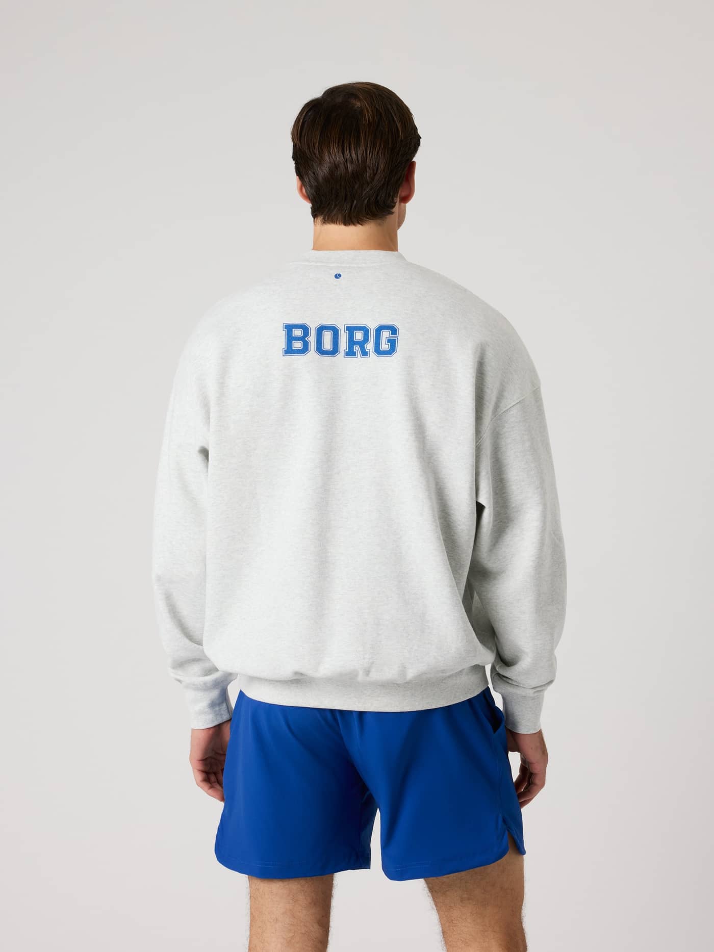 Vista posterior de la Ace Oversized Sweatshirt en Ultra Light Grey Melange (Gris) con logo azul para un estilo de tenis. - Image 2