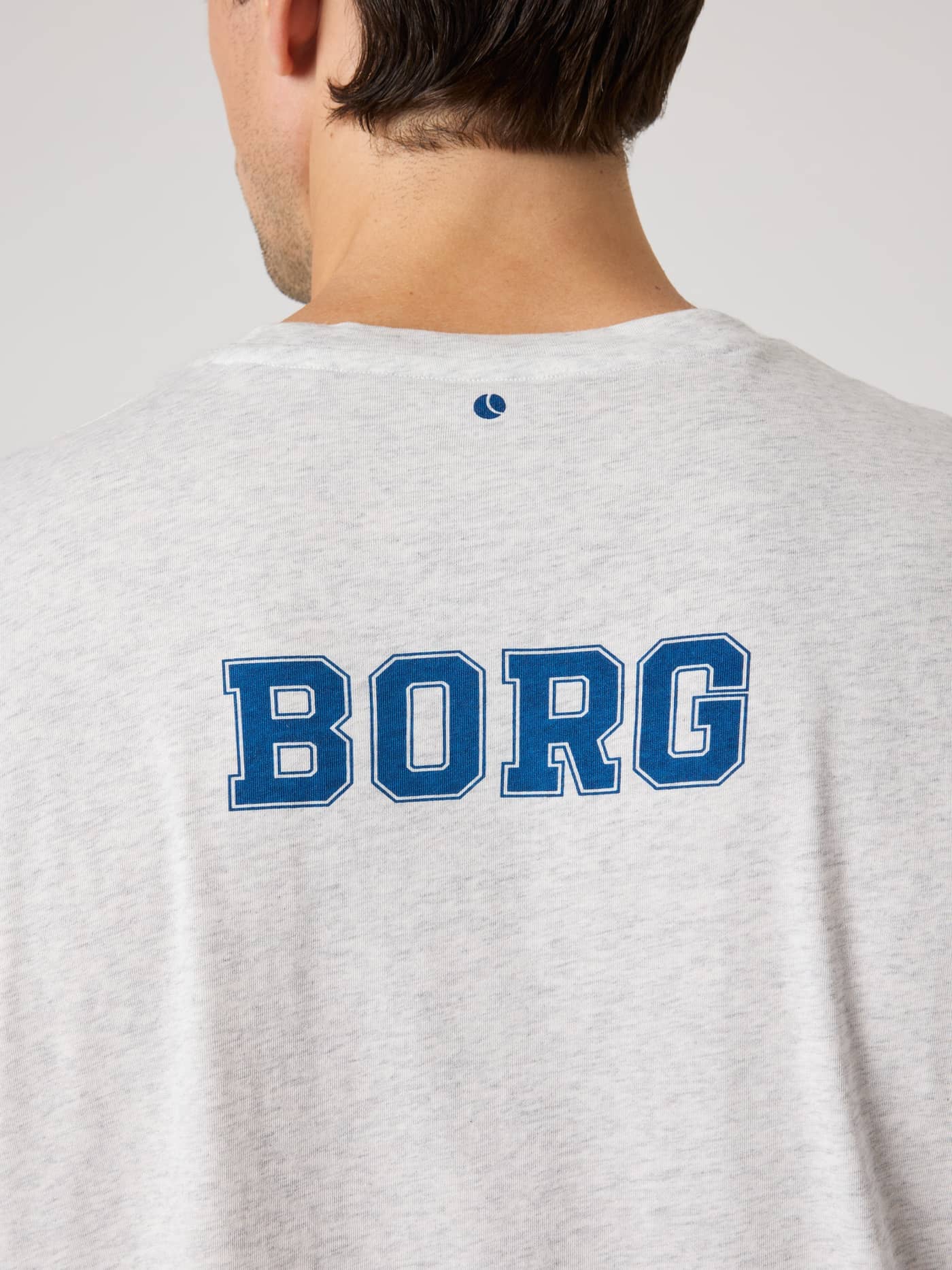 Back view of the Ace Oversized T-Shirt in Ultra Light Grey Melange (Grey) with blue BORG and tennis ball prints. - Image 4