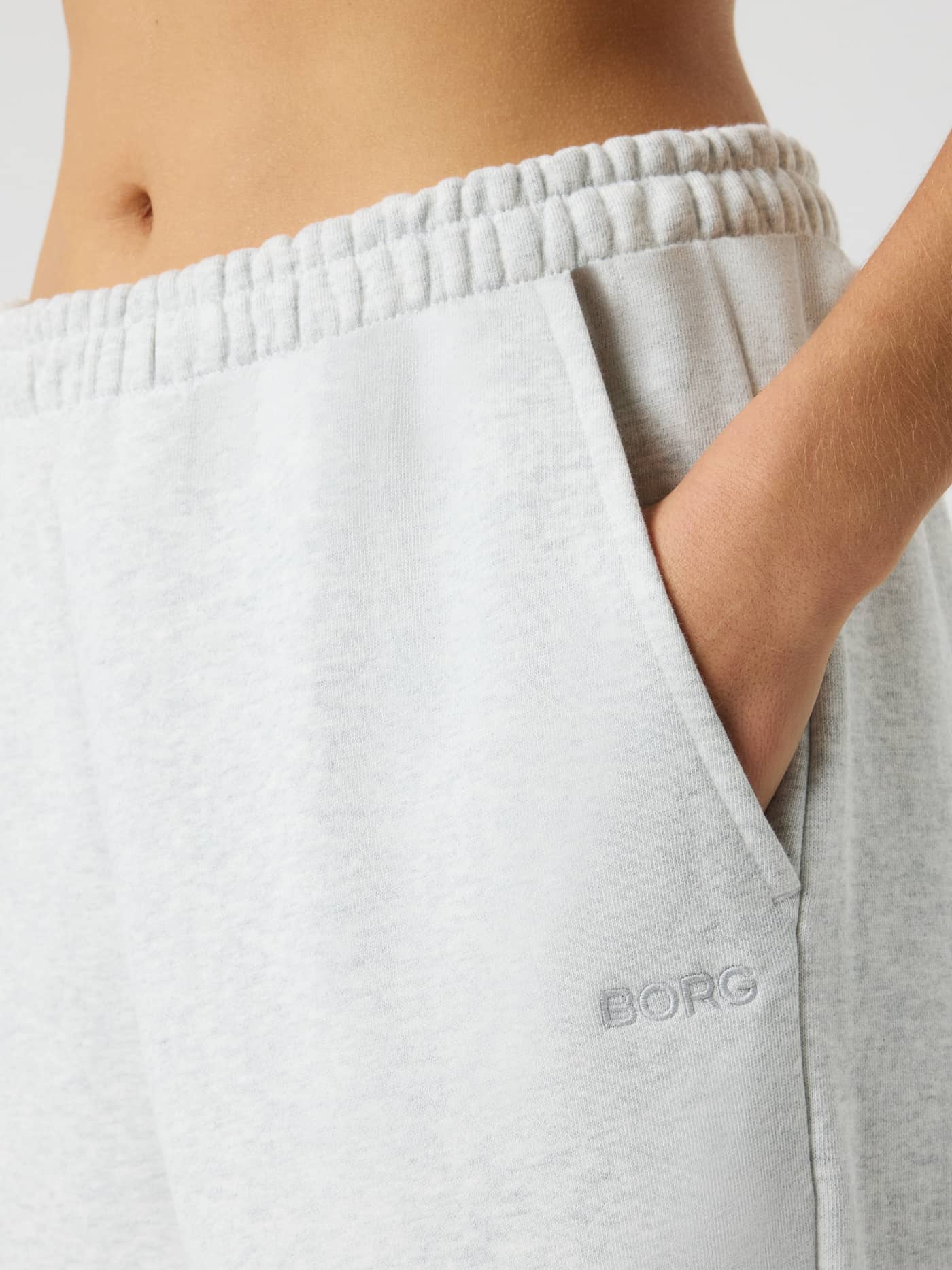 Close-up van de Studio Jersey Shorts in Ultra Light Grey Melange (Grijs) met een zijzak en ton-sur-ton BORG-logo. - Image 4