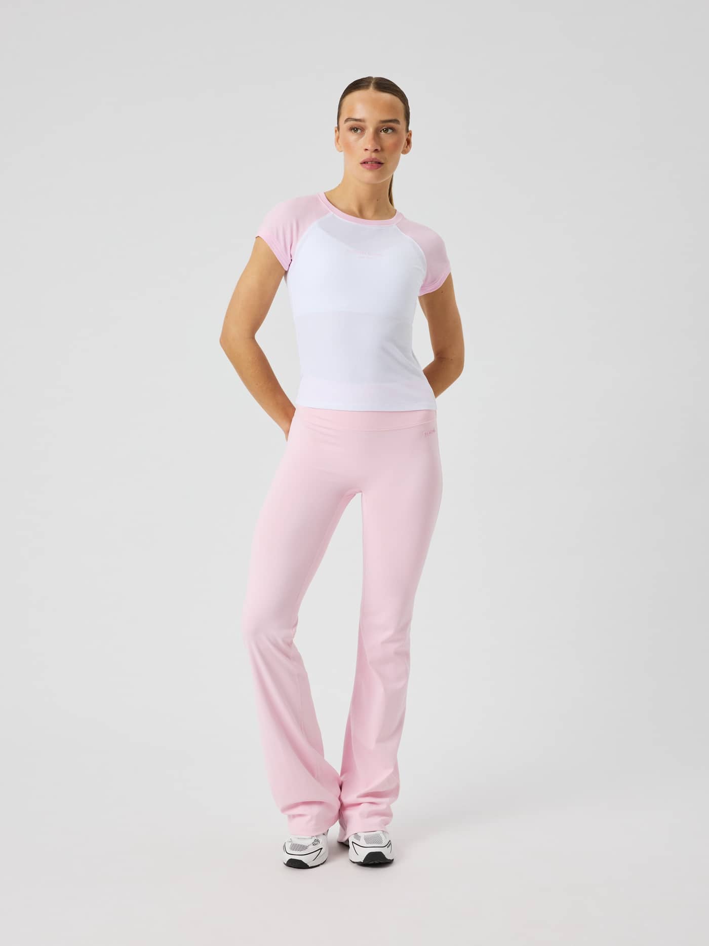 Full-body front view of a woman wearing the slim-fit Studio Ringer T-Shirt in Pink Lady (Pink) with a tennis-inspired style. - Image 4