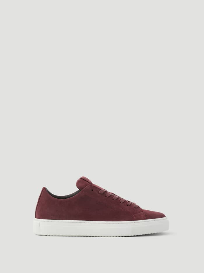 Side view of Men's Classic Suede Sneakers in Red with a premium finish and white sole for a tennis-inspired look.