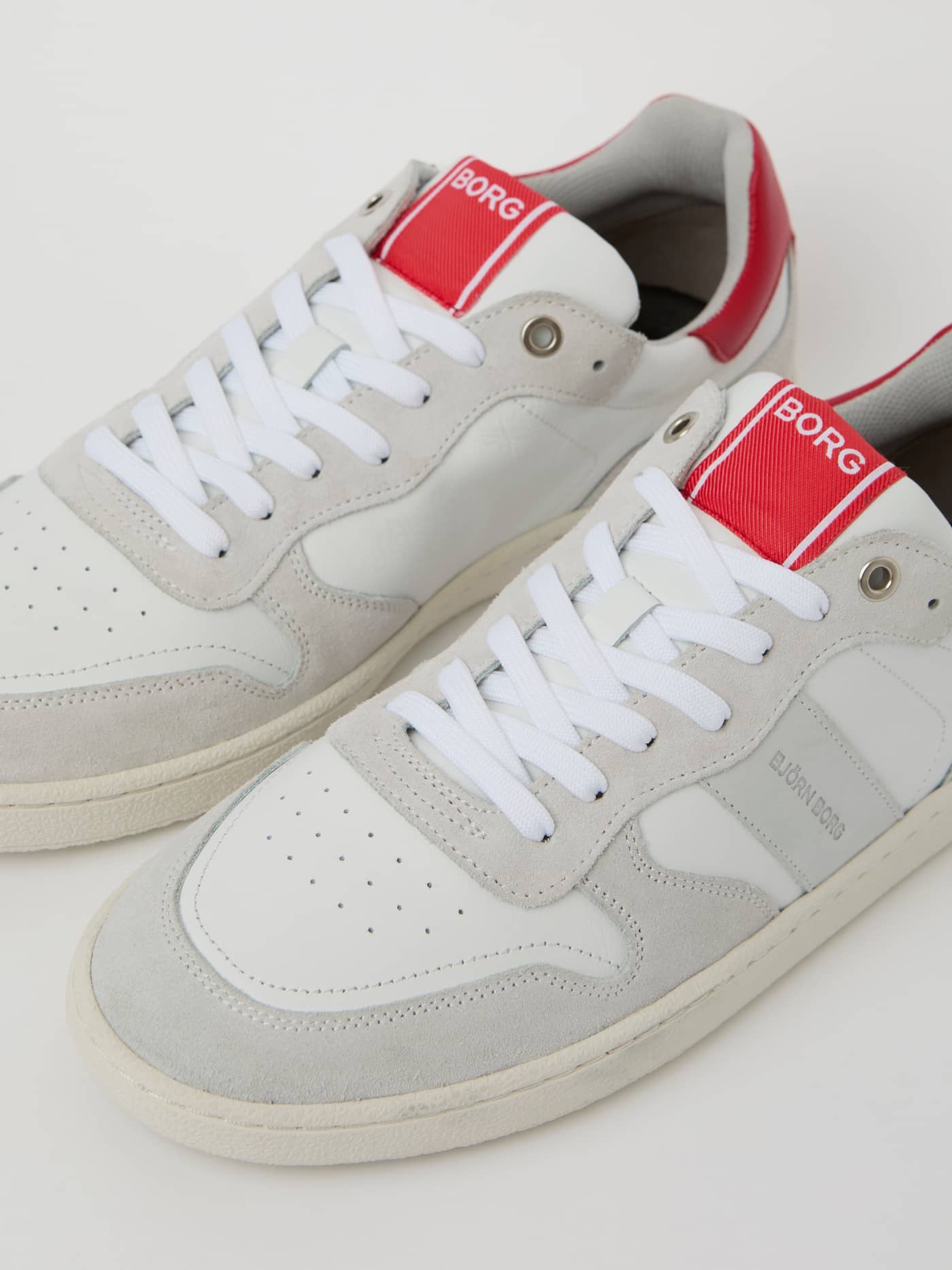 Detailed close-up of the Men's Legacy Leather Sneakers in white and red, featuring a tennis-inspired leather design. - Image 2