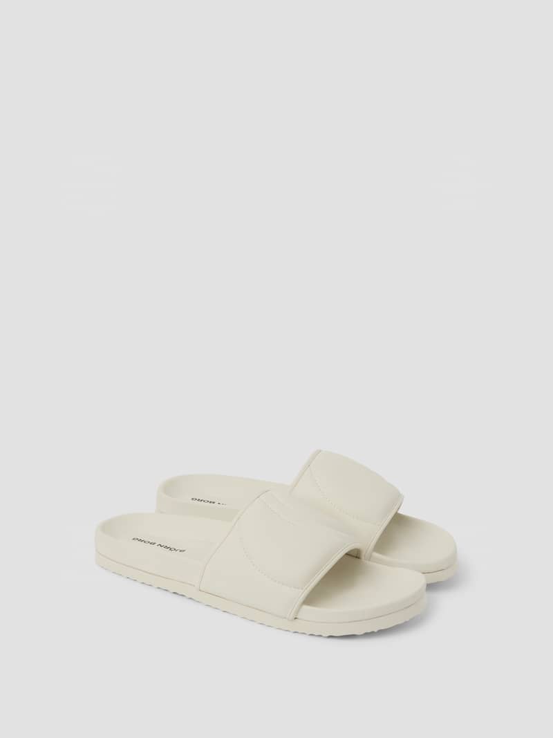 Three-quarter view of the white Unisex Timeout Slides made from durable TPU for lightweight leisure wear.