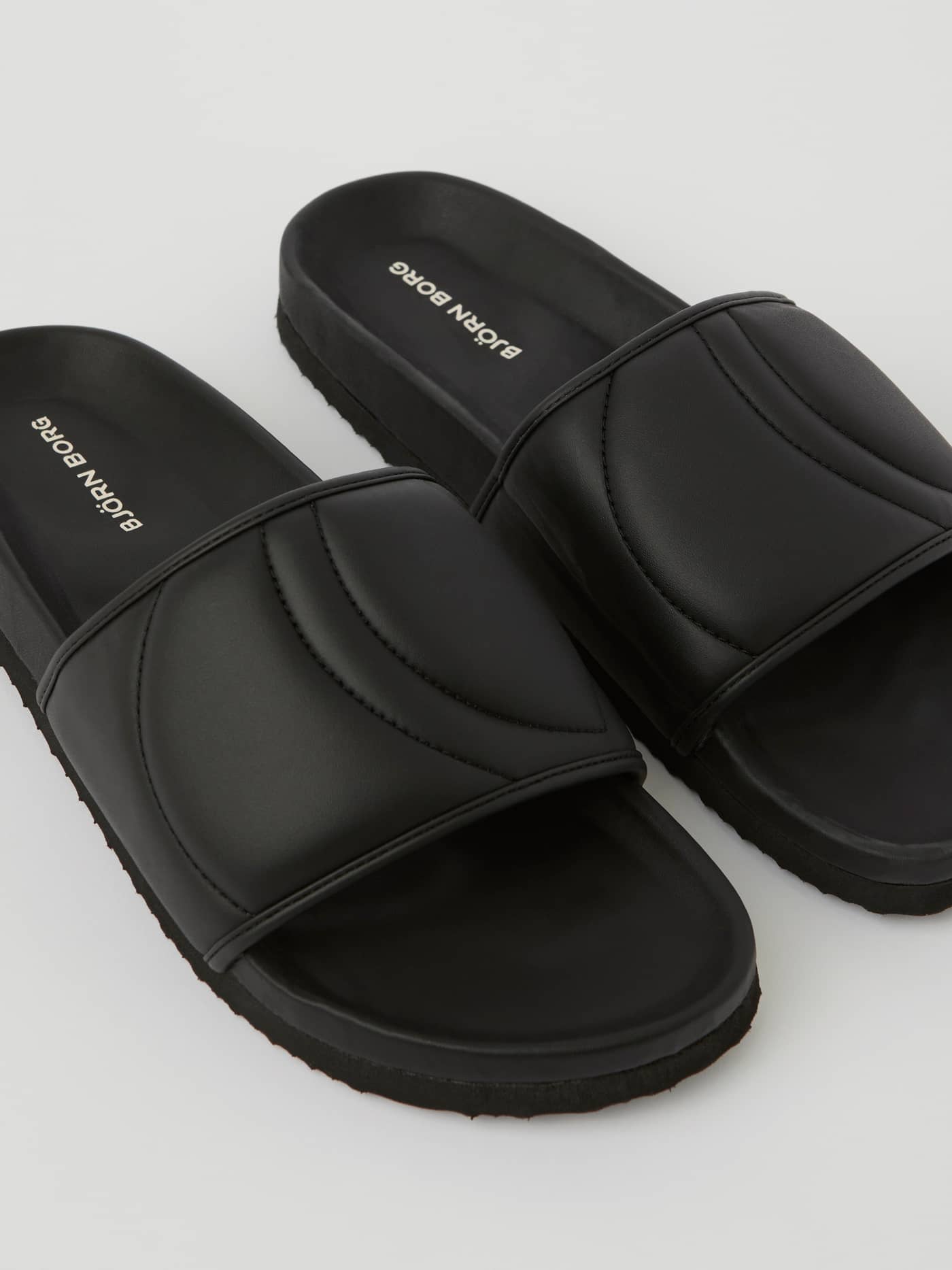 Zwarte Unisex Timeout Slides van duurzaam TPU met witte logo's, een gewatteerde band en comfortabele vrijetijdspasvorm. - Image 2