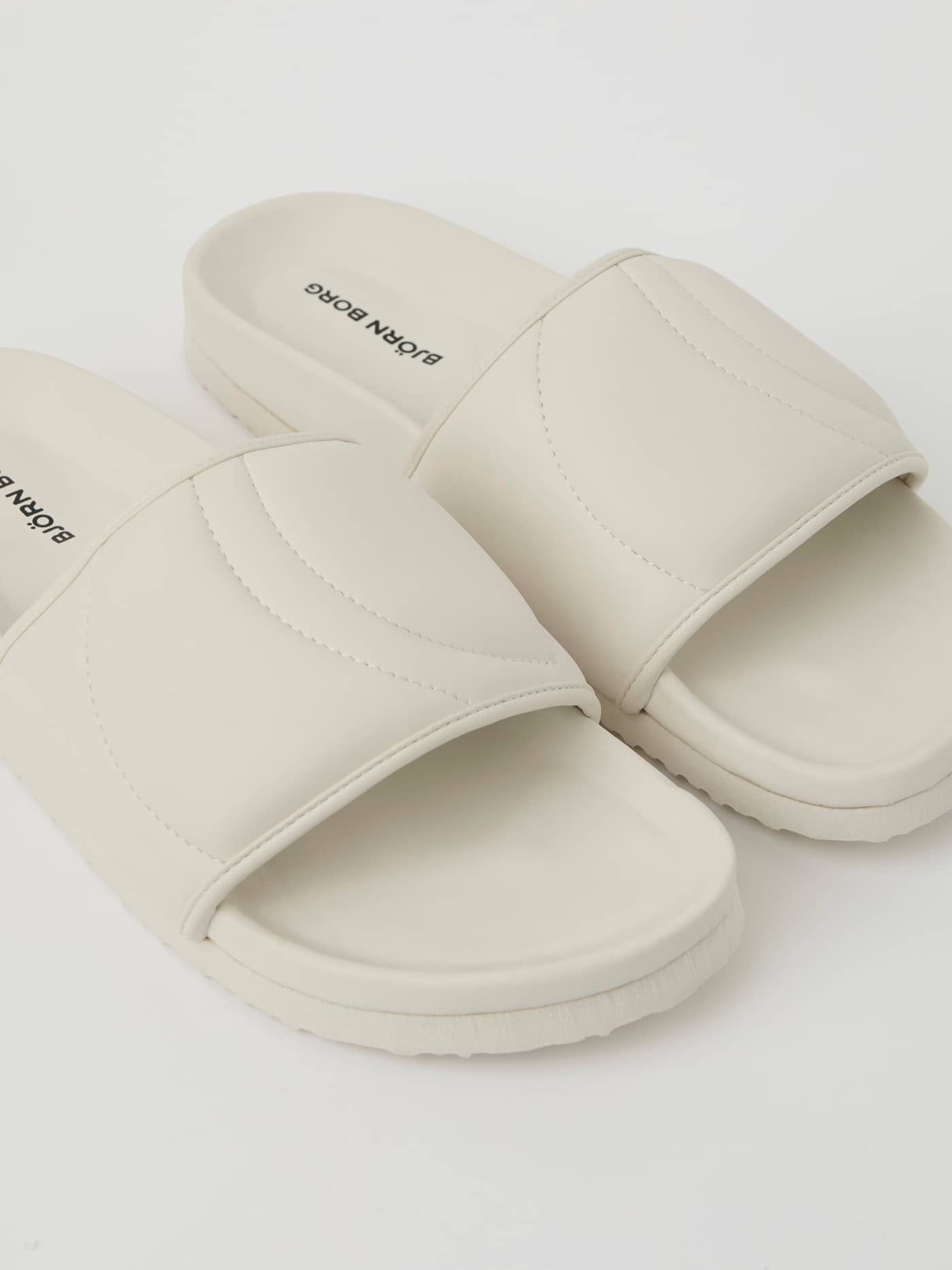 Witte Unisex Timeout Slides van duurzaam TPU met een zwart logo op het voetbed in een gedetailleerde close-up. - Image 2
