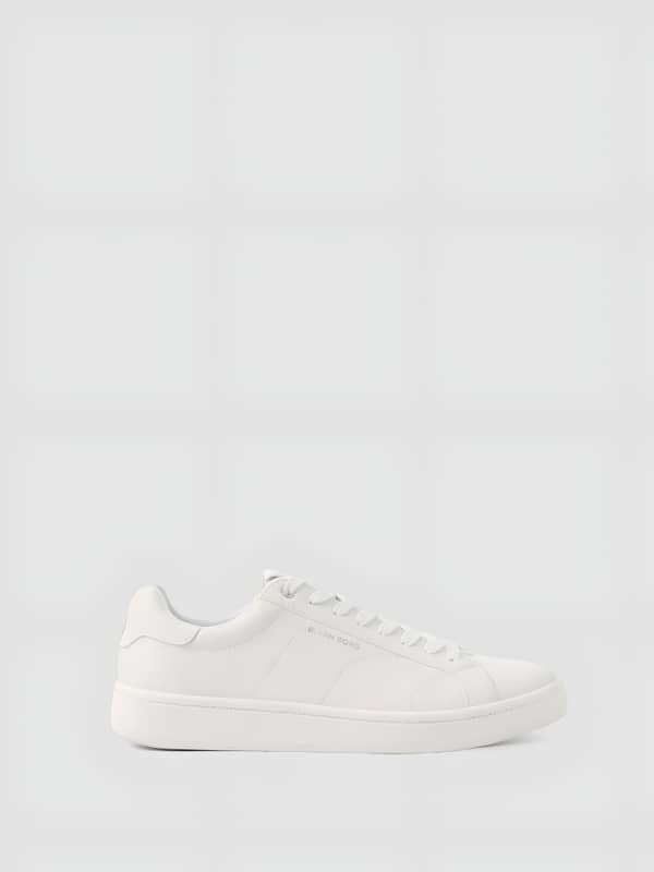 Profil des Unisex Deuce Sneakers en blanc, cuir synthétique, logo argenté et design inspiré du tennis.