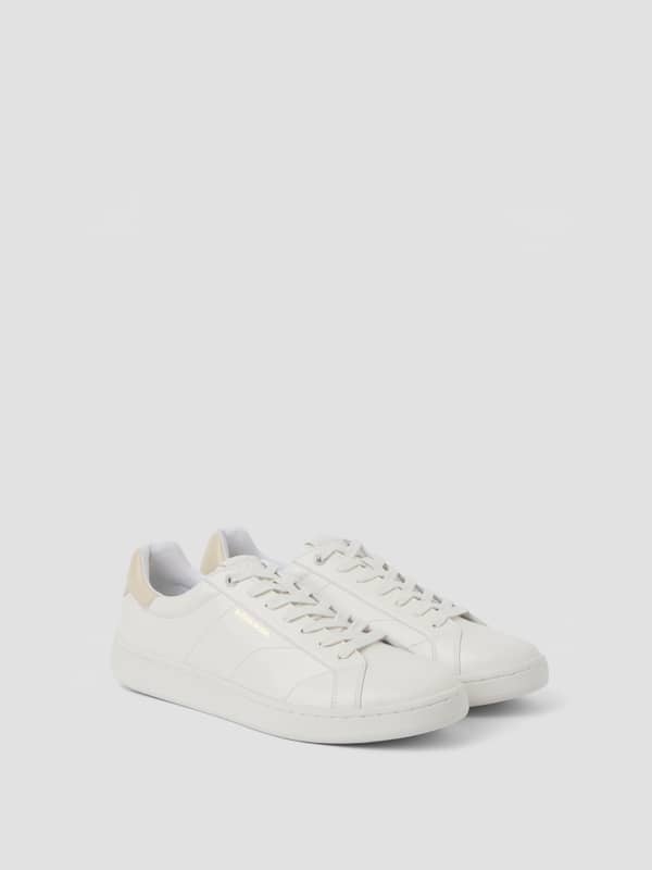 Vue de trois-quarts des Unisex Deuce Sneakers blanches en cuir synthétique pour le tennis avec détails sable.