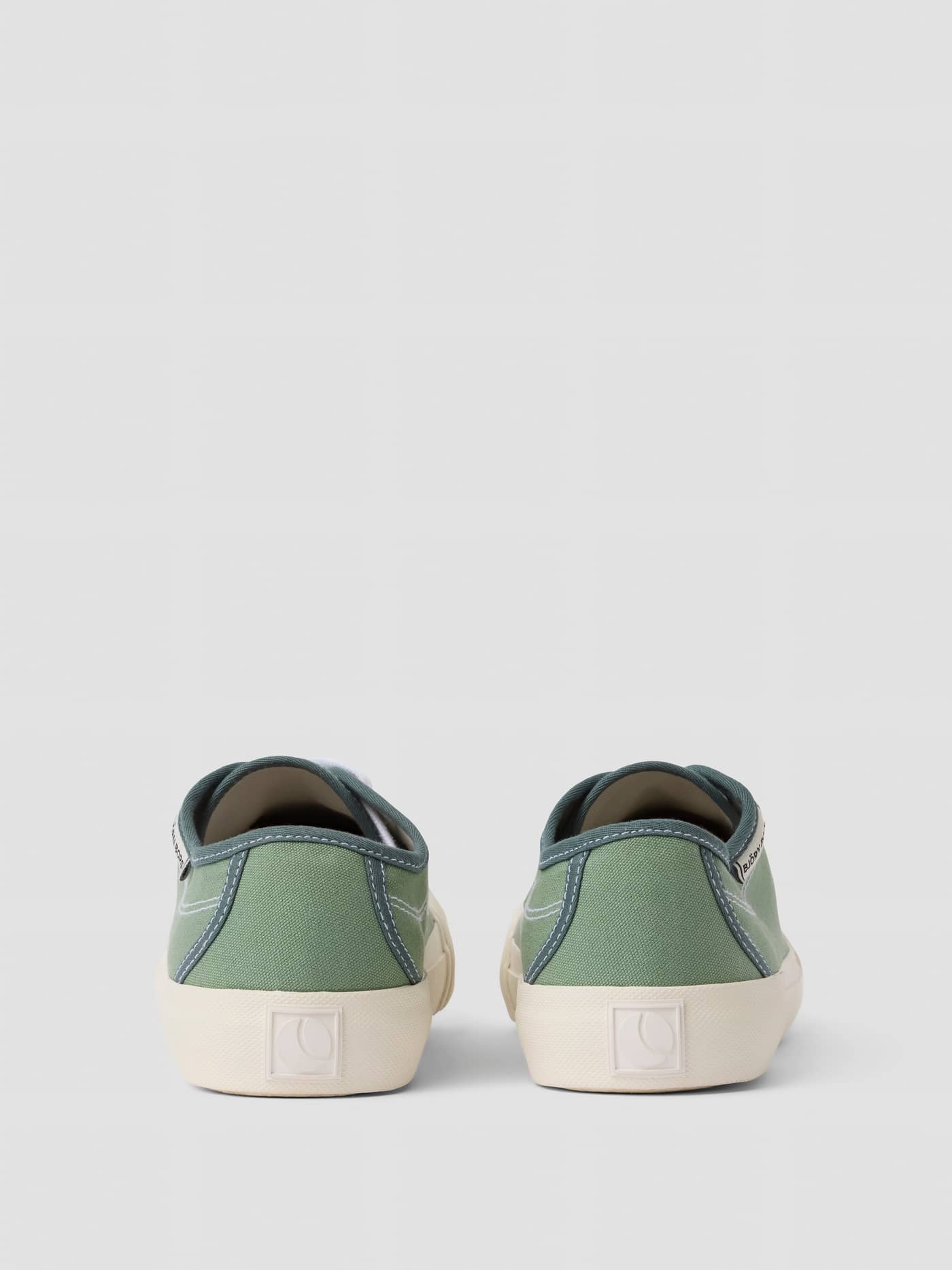 Back view of the green Unisex Smash Sneakers, crafted from cotton canvas with a white logo and tennis-inspired style. - Image 3