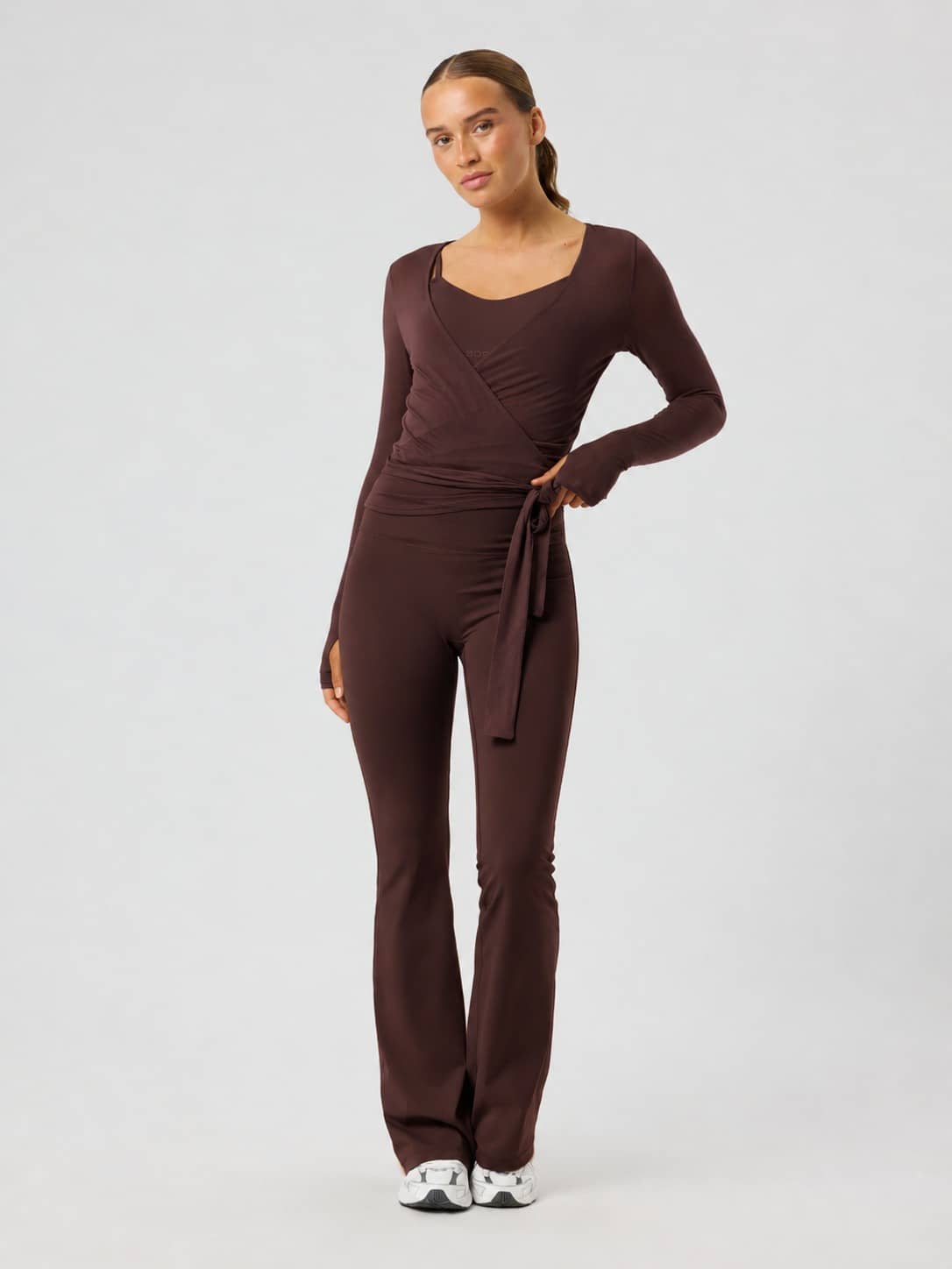 Front view of the Studio Wrapped Top in Coffee Bean (Brown) featuring a slim fit and wrap waist for training and studio wear. - Image 4