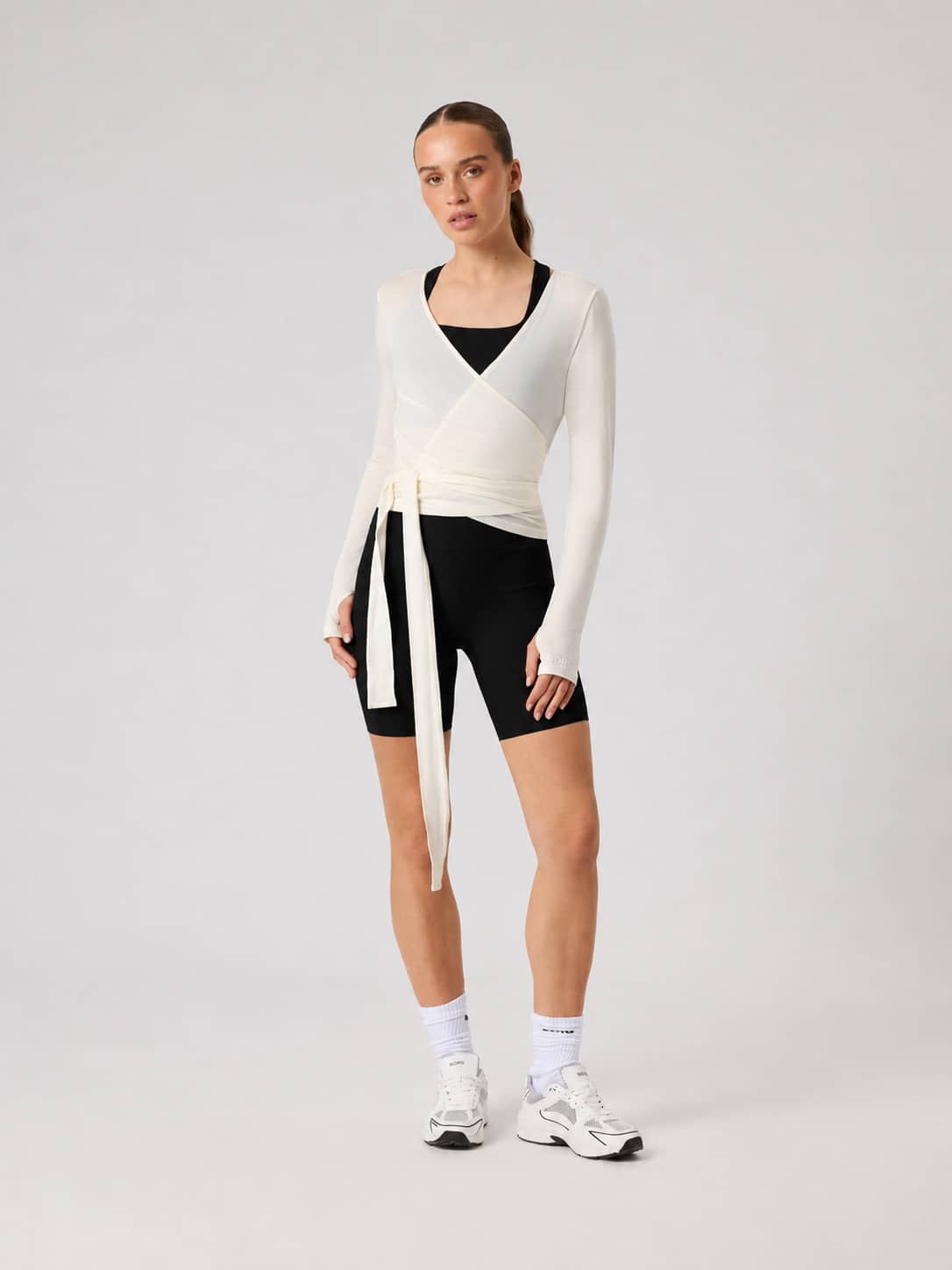 Full-body front view of a model wearing the Studio Wrapped Top in Tofu (White) for training. - Image 3