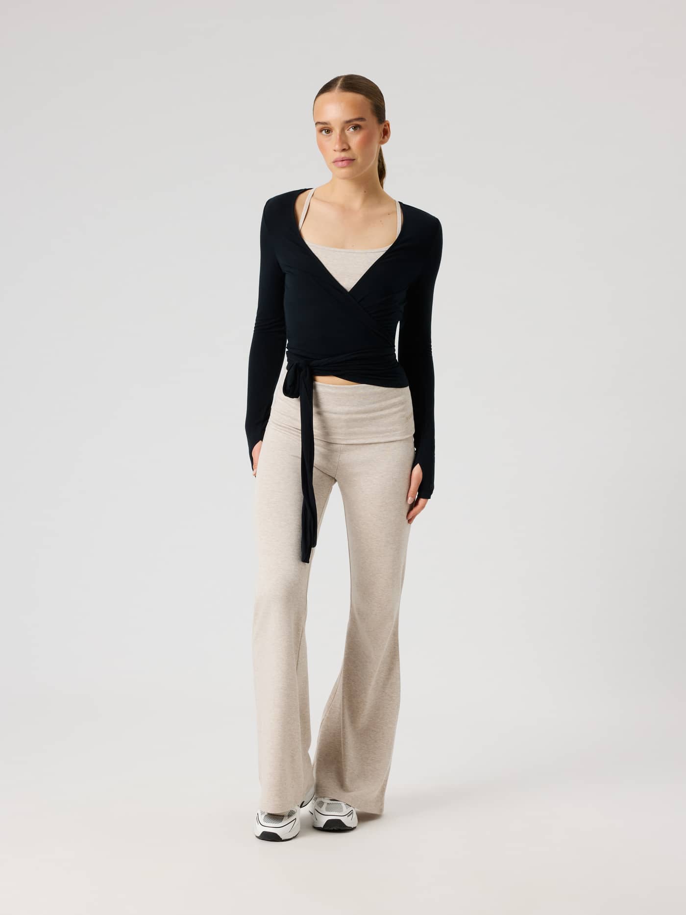 Full-body front view of a model wearing the Studio Wrapped Top in Black Beauty (Black) for a slim training fit. - Image 4