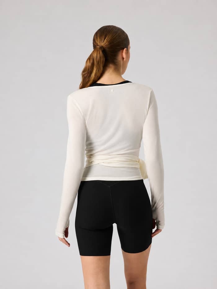 Back view of a model wearing the Björn Borg Studio Wrapped Top in Tofu (White) for training. - Image 2