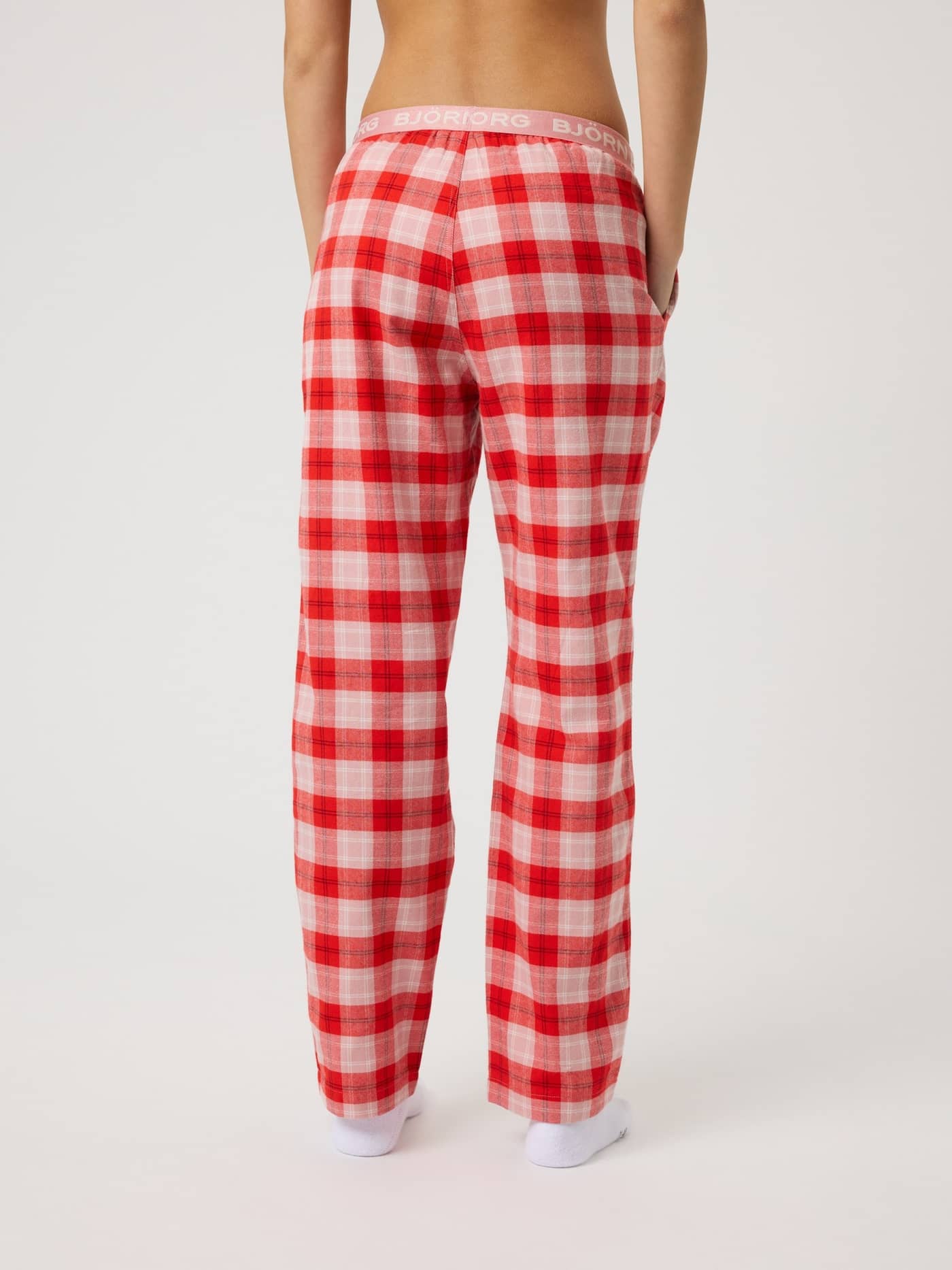 Back view of kids wearing Core Flannel Pyjama Pants in a pink, red and white tartan pattern with a branded pink waistband. - Image 3