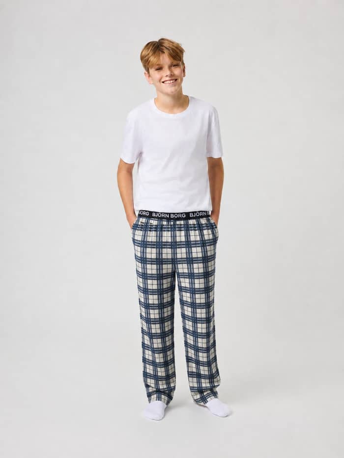 Front view of kids wearing Core Flannel Pyjama Pants in Tri Tartan 1 (Multi) featuring a checked pattern and white logo.