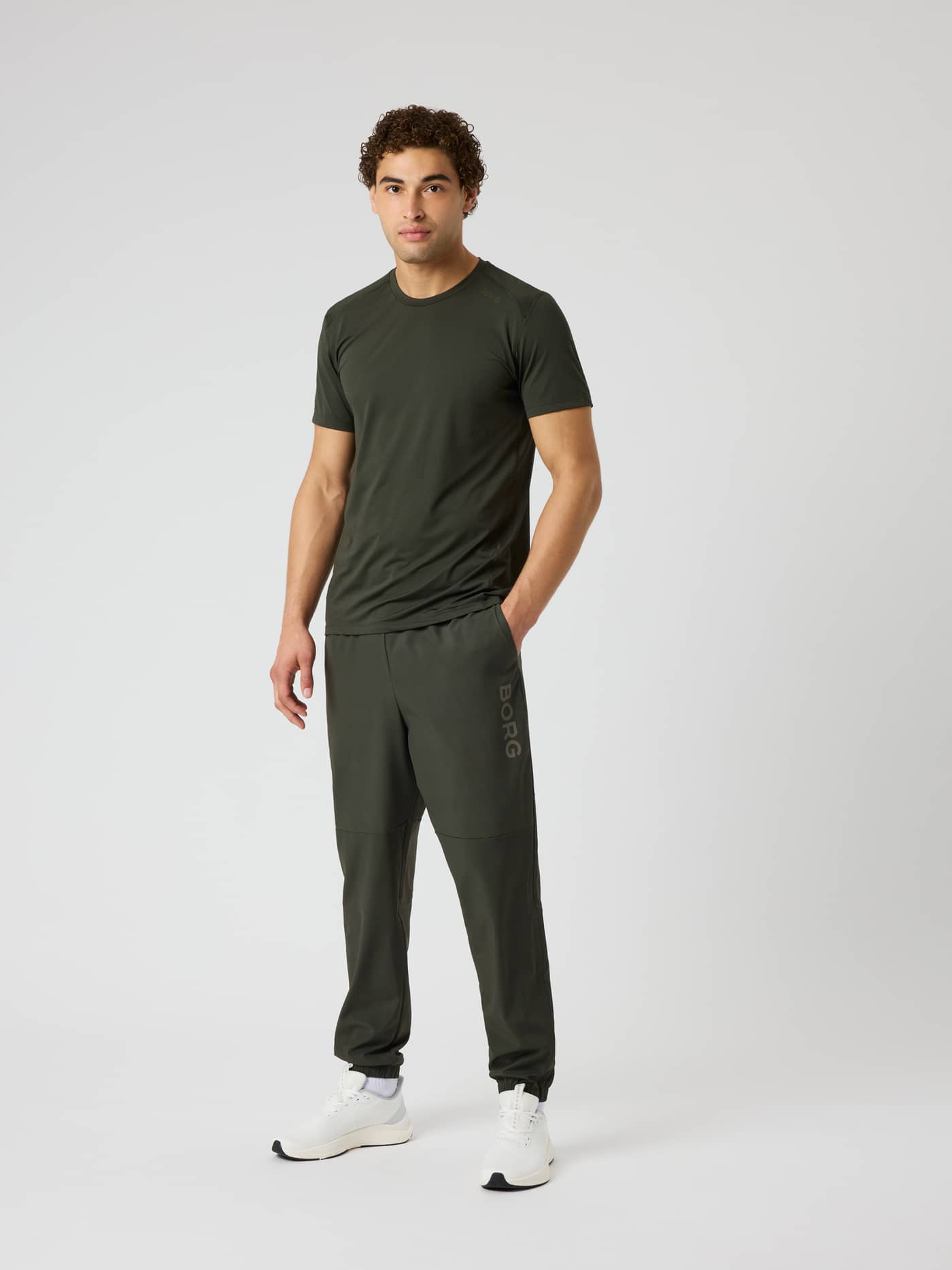 Full-body front view of a model wearing Borg Training Pants in Rosin (Green) with a tonal logo and regular fit. - Image 3