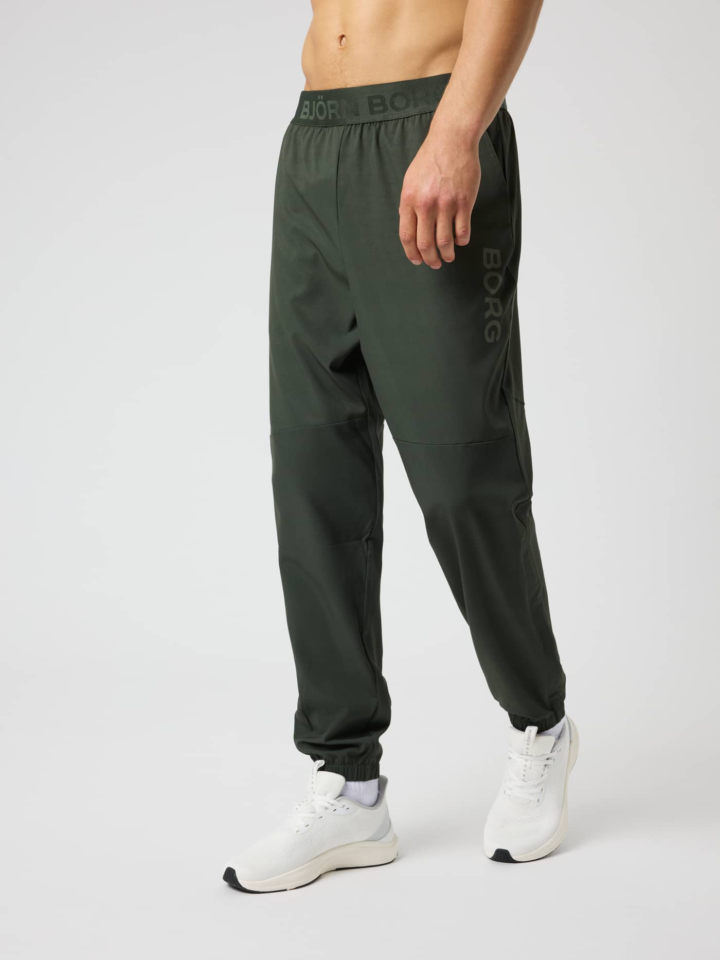 Vue de face d'un modèle en Borg Training Pants en Rosin (Vert), un pantalon de training fonctionnel qui sèche rapidement. - Image 1