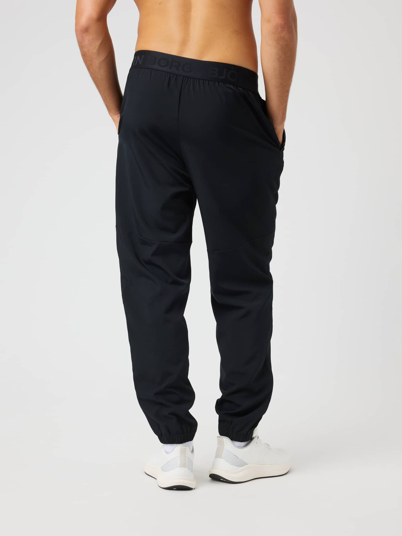Back view of a man wearing Borg Training Pants in Black Beauty (Black) featuring a branded elastic waistband. - Image 2