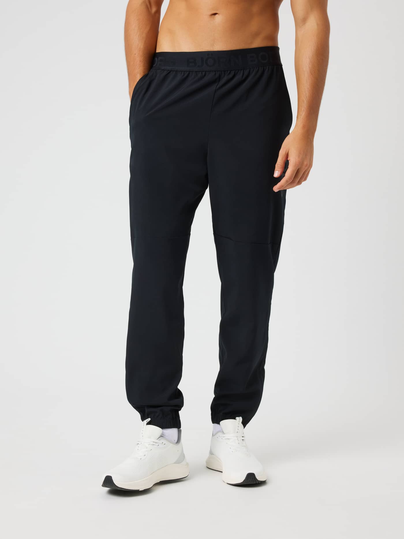Vue de face d'un modèle en Borg Training Pants Black Beauty (Noir) avec une taille élastique à logo noir. - Image 1