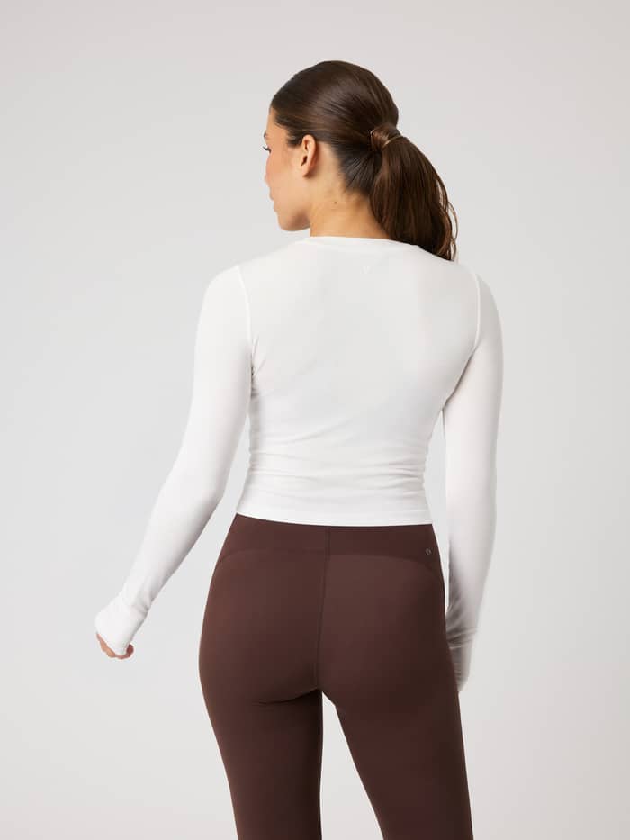Achterzijde van de Studio Ribbed Cropped Long Sleeve in Tofu (wit), met focus op de ronde hals en de geribde textuur.