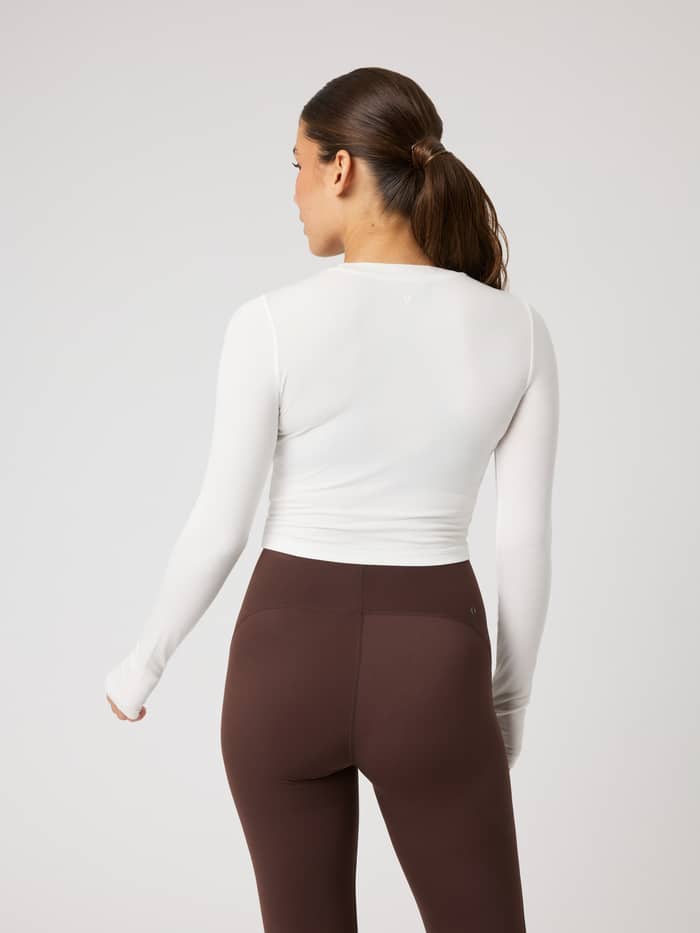 Achteraanzicht van de Studio Ribbed Cropped Long Sleeve in Tofu (Wit) voor functionele training. - Image 3