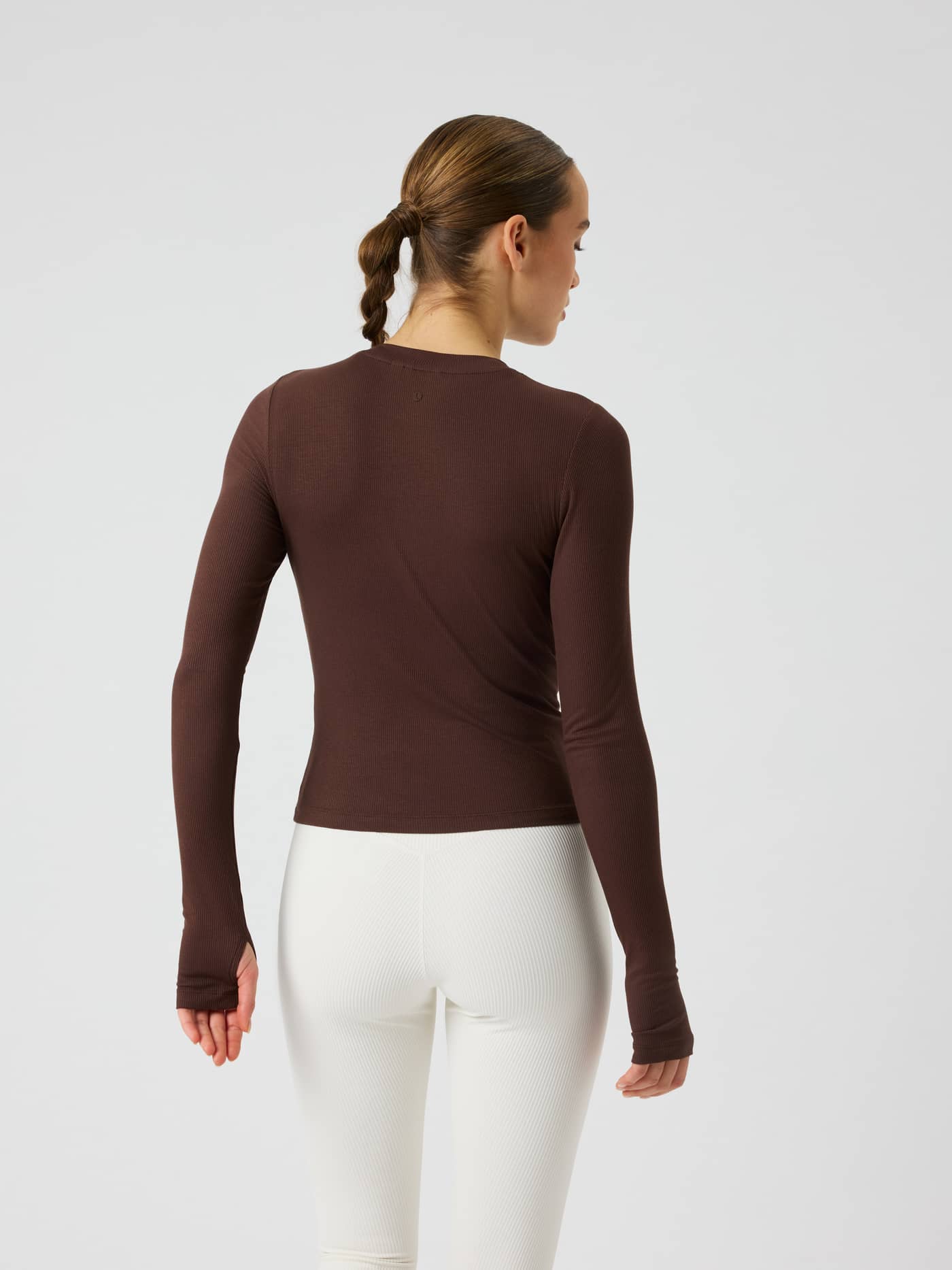 Back view of the Studio Ribbed Cropped Long Sleeve in Coffee Bean (Brown), a ribbed training top with thumb holes. - Image 2