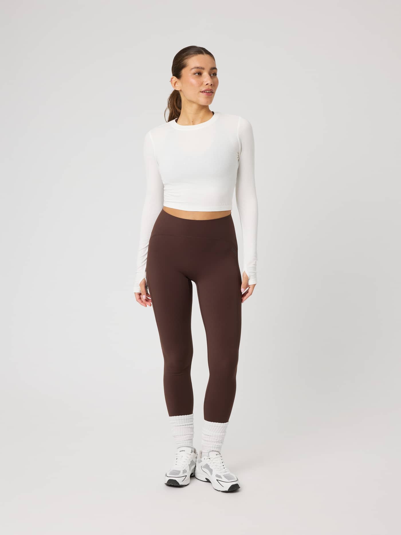 Full-body front view of a model in the Studio Ribbed Cropped Long Sleeve in Tofu (White) for a premium training fit. - Image 4