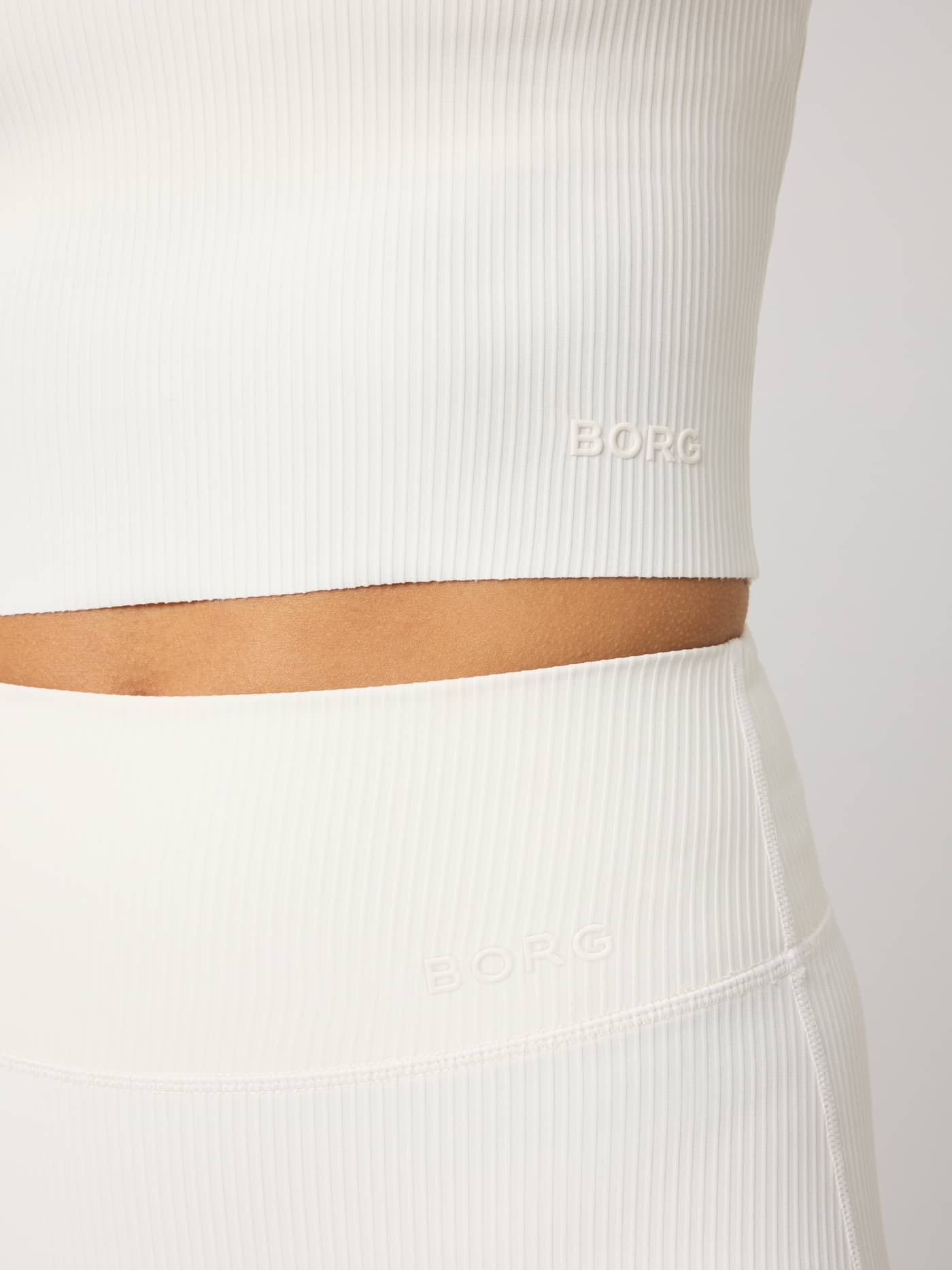 Studio Ribbed V-Neck Top in Tofu (White) featuring a tonal Borg logo and ribbed training fabric in a close-up view. - Image 6