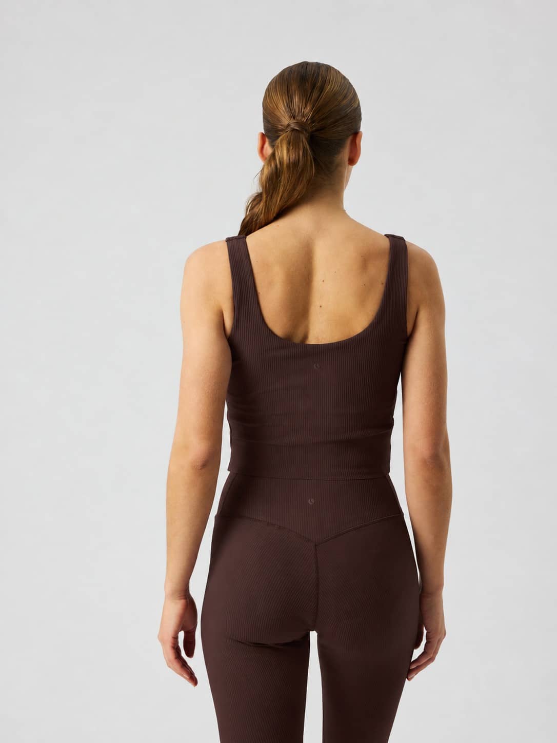 Back view of the Studio Ribbed V-Neck Top in Coffee Bean (Brown), a slim ribbed tank top for training. - Image 2