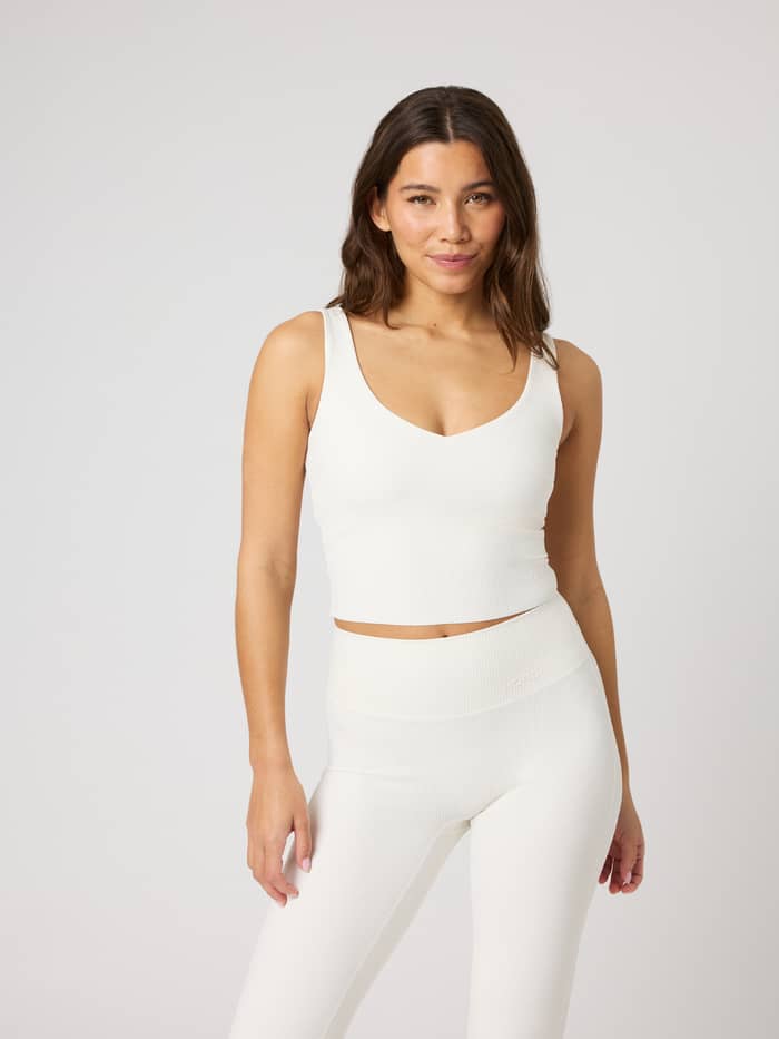 Vooraanzicht van de Studio Ribbed V-Neck Top in Tofu (Wit), een nauwsluitende cropped trainingstop met ribtextuur.