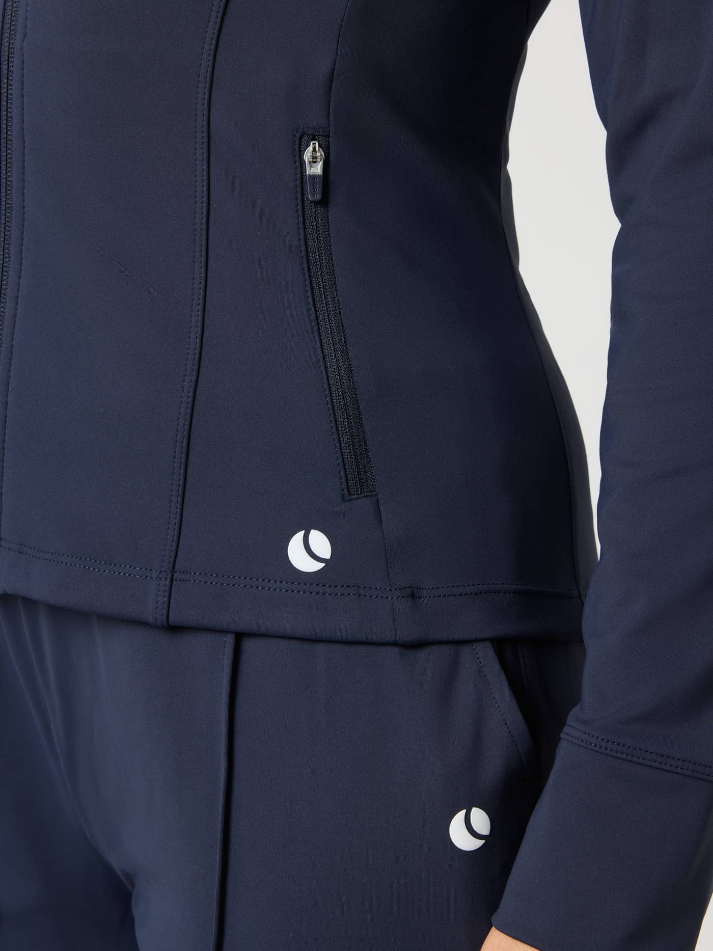 Close-up of the Ace Track Jacket in Night Sky (Navy) featuring a zip pocket and tennis ball print for court training. - Image 4
