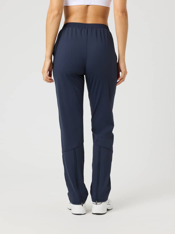 Ace Track Pants i Night Sky (Marineblå) set bagfra på en kvinde til tennis med regular fit og lynlåse i benåbningerne. - Image 2