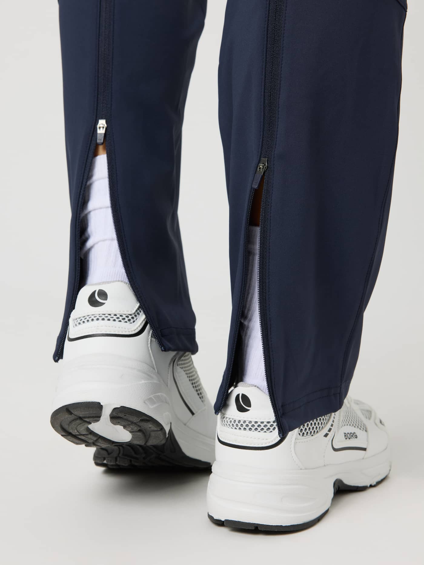 Close-up of Ace Track Pants in Night Sky (Navy) featuring functional zippered leg openings for tennis and padel. - Image 6