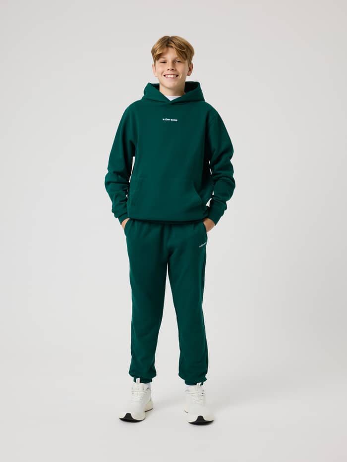 Borg Classic Hoodie til kids i Rain Forest (Grøn) set forfra i fuld figur med hvidt logo og kængurulomme til tennis. - Image 3